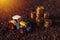 Agricultural tractor toy and golden coins on fertile soil land