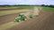 Agricultural tractor with trailer plowing on farming field. Farming machinery