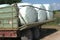 Agricultural trailer loaded with six hay silage bales wrapped with enzyme infused foil