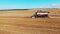 Agricultural vehicle is riding and harvesting grain