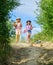 Agriculture concept. Adorable girls in hats going planting plants. Kids siblings having fun at farm. Eco farming concept