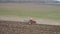 Agriculture and farming - tractor plough a field in early spring aerial footage