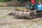 Agriculture farmland,tractor with plough ploughing a soil field