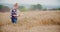 Agriculture female farmer walking in wheat field with digital tablet