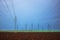 Agriculture field, electric posts, substation towers and industrial chimneys and factory