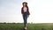 Agriculture. girl farmer in rubber boots walk country road near a green field of wheat grass. farmer worker go home