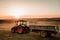 Agriculture industry machinery. Harvesting details with tractor and trailer transporting harvest at sunset