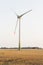 Agriculture landscape with wind turbines, warm evening sun.