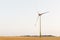 Agriculture landscape with wind turbines, warm evening sun.