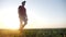 Agriculture. man farmer in rubber boots walk country road near crop a green field of wheat grass. Farmer worker goes