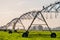 Agriculture modern irrigation. watering spray machine set on the green grassland field with blue sky and warm light scene. I