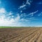 Agriculture plowed field and clouds in sunset