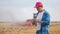 Agriculture. Portrait of a farmer working on a digital tablet in a field in the background a tractor plows the ground in