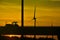 Agriculture and renewable energy, shadow of a passing tractor and windmill at a fantastic sunset