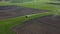 Agriculture tractor spreading fertilizer on spring field, aerial