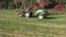 Agriculture tractor with sprinkler on autumn crop rapeseed field