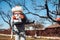 agriculture worker wearing protective clothing and spraying industrial pesticide in fruit orchard