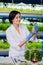 Agriculturist wearing blue gloves holding glass tube with plant