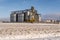 Agro silos granary elevator in winter day in snowy field. Silos on agro-processing manufacturing plant for processing drying