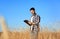 Agronomist with clipboard in wheat field