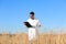 Agronomist with clipboard in wheat field.  grain crop