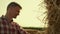 Agronomist examining hay bale in sunlight closeup. Focused farmer inspecting