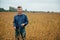 Agronomist holds tablet touch pad computer in the soy field and examining crops before harvesting. Agribusiness concept.