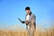 Agronomist with laptop in wheat field.