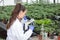 Agronomist with microscope in greenhouse