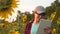 An agronomist studies a sunflower crop and laughs. Happy farmer woman working with a tablet in a sunflower field in