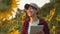 An agronomist studies a sunflower crop and laughs. Happy farmer woman working with a tablet in a sunflower field in