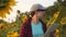 An agronomist studies a sunflower crop and laughs. Happy farmer woman working with a tablet in a sunflower field in