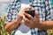 Agronomist typing text message on smartphone out in corn field