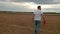 Agronomist in white t-shirt and jeans walking in wheat field.