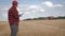 Agronomist young man using smartphone in agriculture farm. Farmer with mobile phone in a wheat field on the background