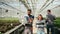 Agronomy engineers walking with laptop in a greenhouse