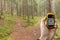 AHRNTAL, ITALY - SEPTEMBER 22, 2014: A trekker is finding the right position in the forest via gps in a cloudy autumnal day