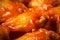 AI generated illustration of an array of succulent hot wings drenched in a spicy sauce