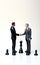 AI generated illustration of a couple of businessmen handshaking with a chess piece on the background