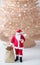 AI generated illustration of Santa Claus with a bag full of Christmas gifts