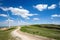 AI generated illustration of a scenic view of several wind turbines on the rolling hills