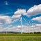 AI generated illustration of a scenic view of several wind turbines on the rolling hills