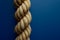 AI generated illustration of a sturdy rope made from tightly woven fibers on a blue background