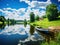 Ai Generated illustration Wildlife Concept of Spring summer landscape blue sky clouds river boat green trees in Sweden