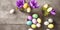 AI generated image of Pastel colored Easter eggs on a stone table with crocus flowers, seen from above