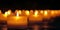 AI illustration of multiple lit candles in a row surrounded by soft yellow glowing light