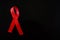 AIDS concept. Red ribbon on black background
