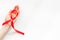 AIDS disease symbol. Red ribbon in hands on white background top view copy space
