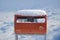 AIJEN, NETHERLANDS - DECEMBER 6, 2021: Official orange postbox covered with fresh snow