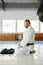 Aikido master sitting on floor and looking at folded black hakama